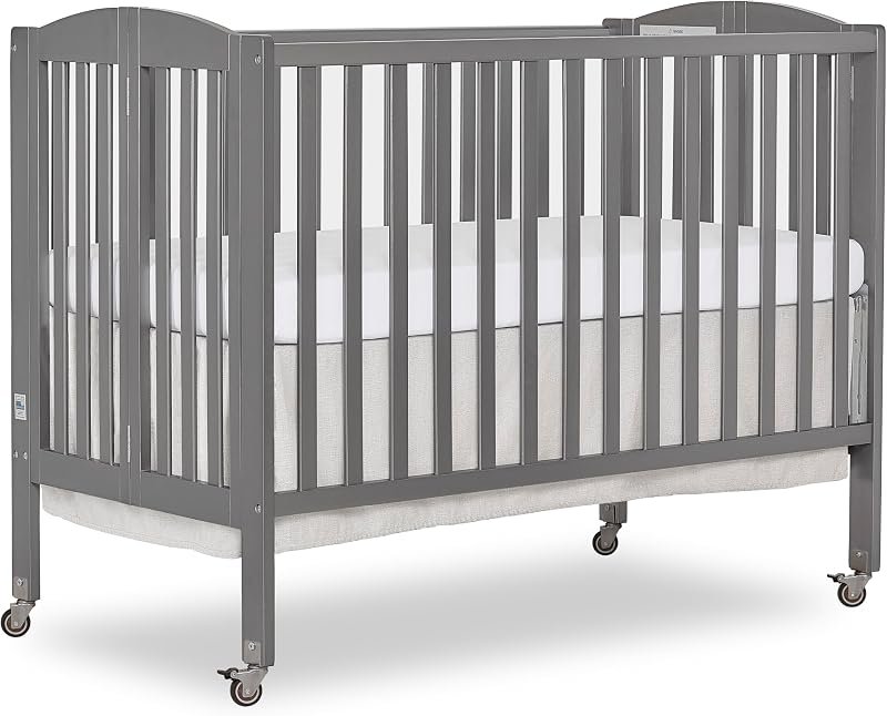Dream On Me grey folding crib with locking wheels, full side view on white background